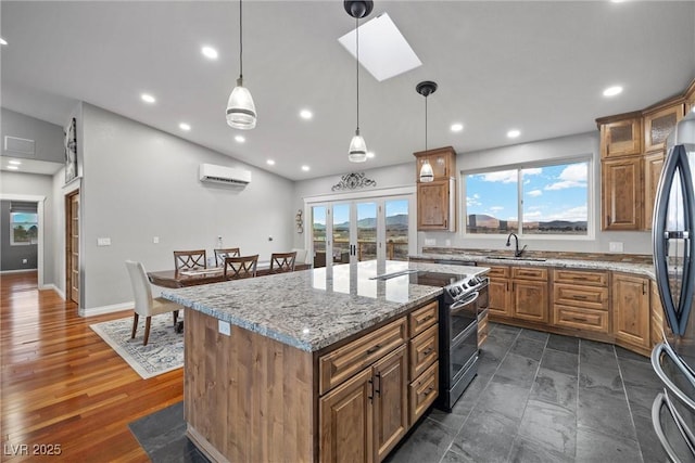 kitchen with lofted ceiling with skylight, range with two ovens, refrigerator, a wall mounted AC, and a sink