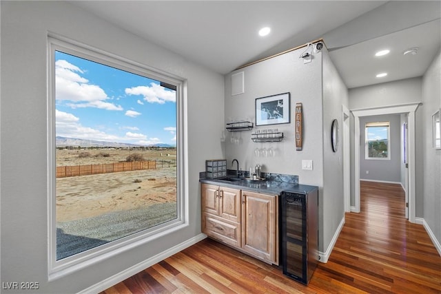 bar featuring wet bar, wine cooler, wood finished floors, and baseboards