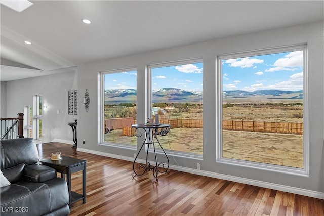 living area with recessed lighting, a mountain view, baseboards, and wood finished floors