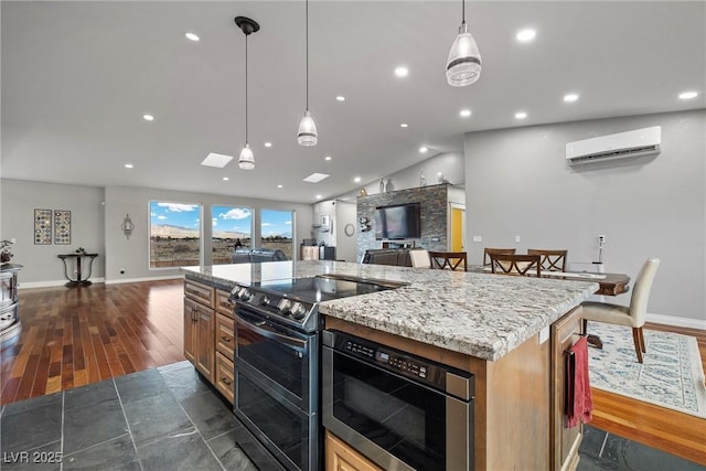 kitchen featuring a center island, dark wood finished floors, stainless steel appliances, and a wall unit AC