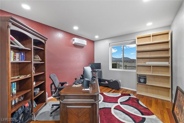 home office with recessed lighting, baseboards, wood finished floors, and a wall mounted AC