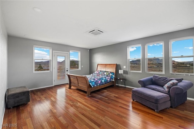 bedroom featuring hardwood / wood-style floors, access to exterior, multiple windows, and visible vents