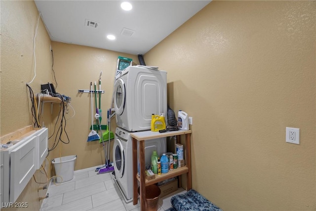 washroom featuring laundry area, recessed lighting, visible vents, and stacked washing maching and dryer