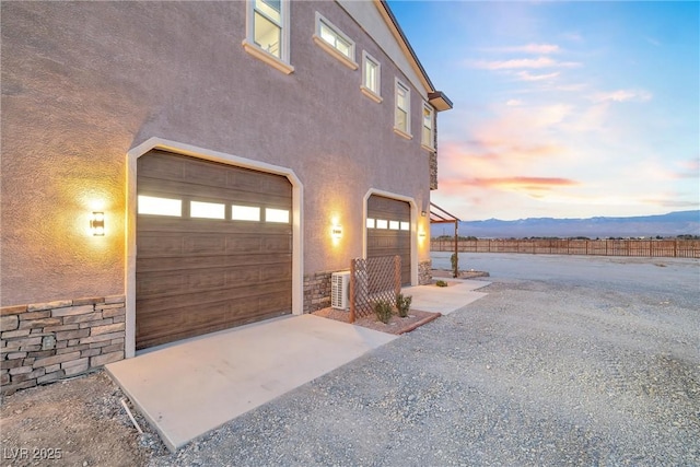 garage with gravel driveway and fence