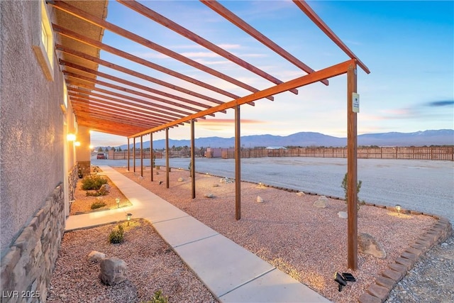 view of patio featuring a mountain view, a pergola, and fence