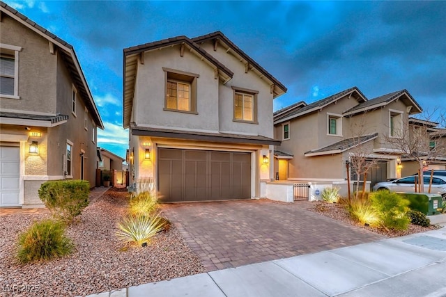 traditional home with a garage, driveway, and stucco siding