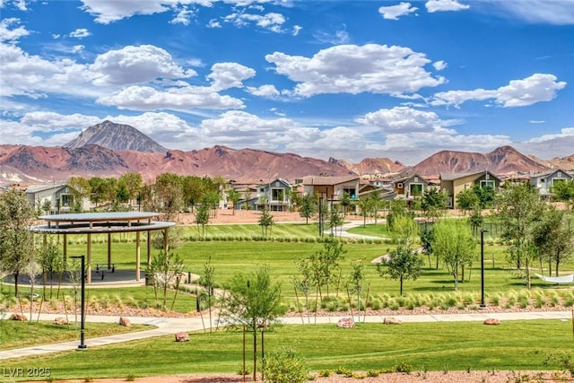 surrounding community with a mountain view and a lawn