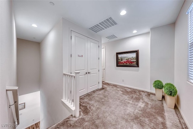 hall with carpet, recessed lighting, an upstairs landing, and visible vents