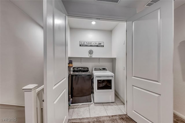 laundry area with washer and clothes dryer, light tile patterned floors, laundry area, and visible vents