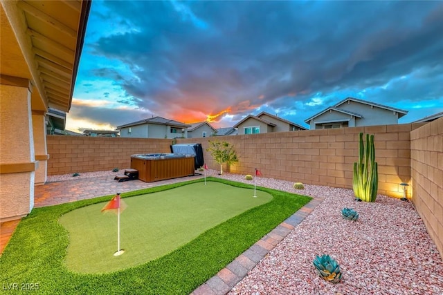 view of yard with a hot tub and a fenced backyard