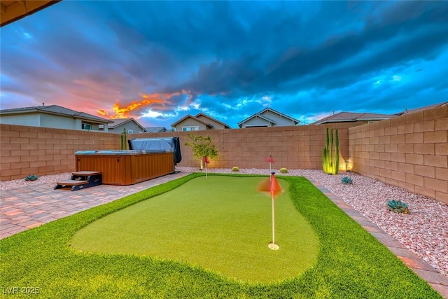 view of yard with a fenced backyard, a hot tub, and a patio