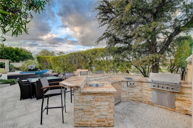 view of patio with a sink, exterior kitchen, outdoor dry bar, and a grill