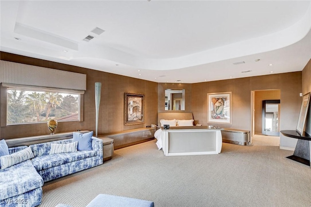 carpeted living area featuring a raised ceiling, recessed lighting, and baseboards