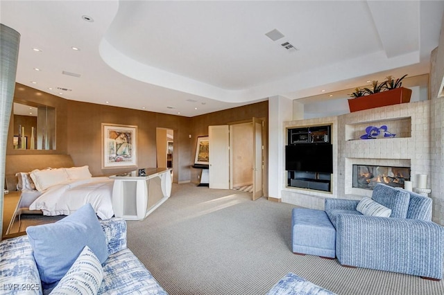 living room with visible vents, recessed lighting, a fireplace, a raised ceiling, and light colored carpet