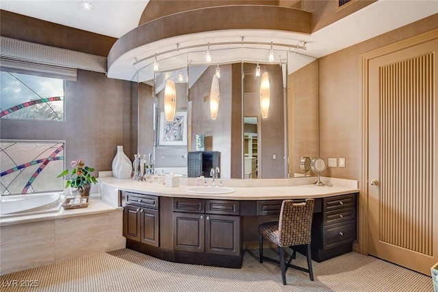 bathroom featuring vanity, a bath, and rail lighting