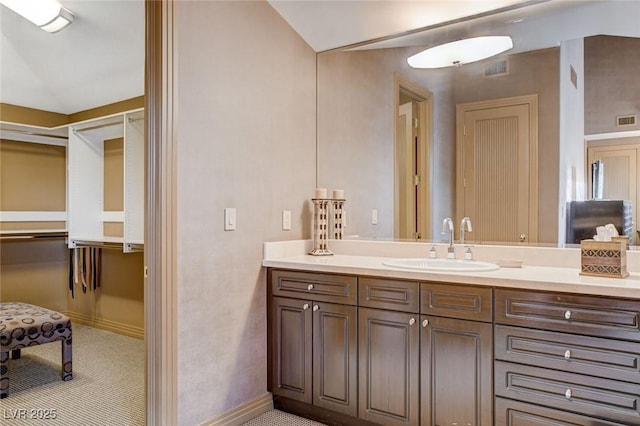 bathroom featuring visible vents, vanity, and baseboards