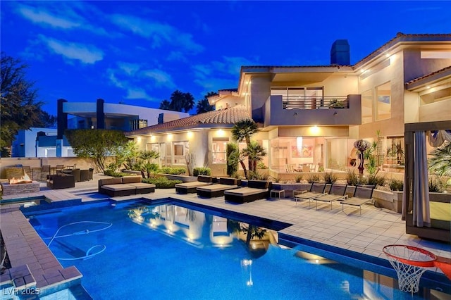 pool at twilight featuring a fenced in pool, an outdoor hangout area, and a patio