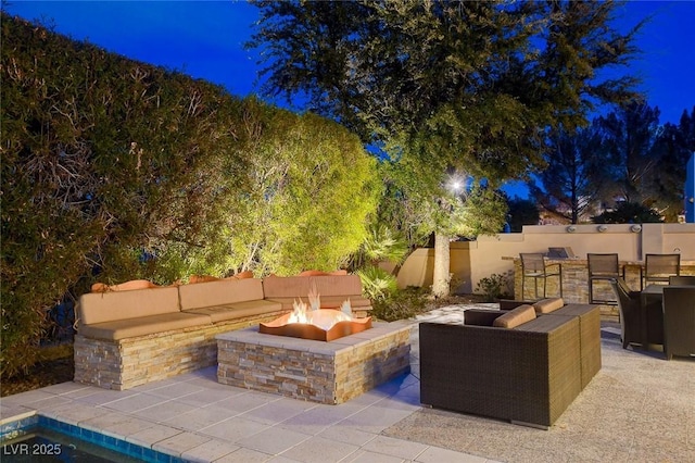 view of patio with an outdoor fire pit and fence