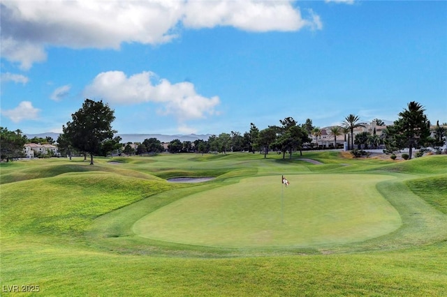 view of community with golf course view and a yard