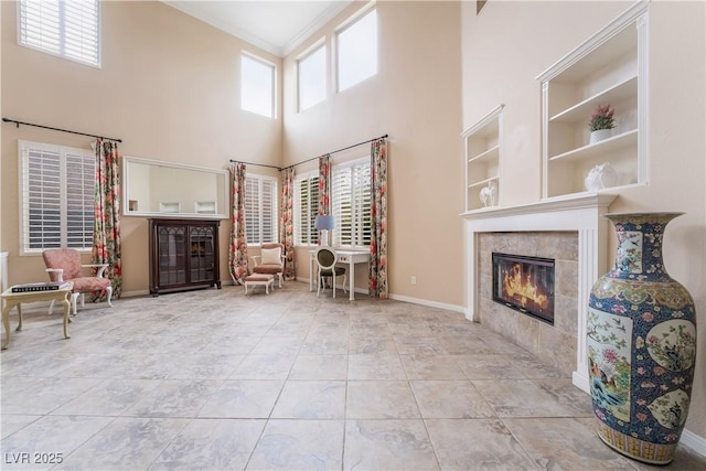 872 Timber Walk Dr, Henderson, NV 89052 - sitting room featuring baseboards, ornamental molding, a towering ceiling, a tiled fireplace, and tile patterned floors