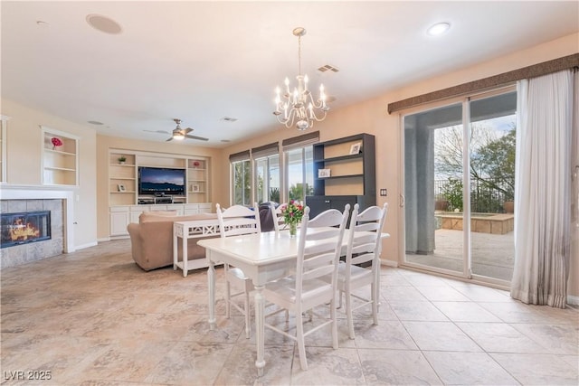 872 Timber Walk Dr, Henderson, NV 89052 - dining space featuring visible vents, baseboards, a tiled fireplace, built in features, and ceiling fan with notable chandelier