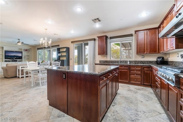 872 Timber Walk Dr, Henderson, NV 89052 - kitchen with visible vents, stainless steel gas cooktop, under cabinet range hood, a wealth of natural light, and a center island