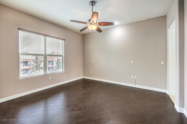 spare room with baseboards, dark wood-type flooring, and a ceiling fan