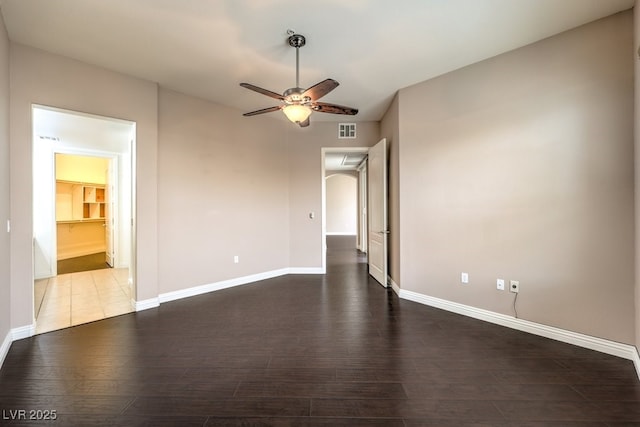 unfurnished room with visible vents, wood finished floors, baseboards, and ceiling fan