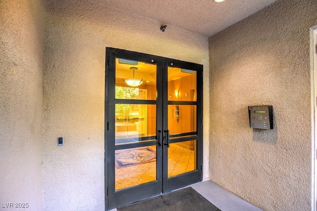 entrance to property featuring french doors and stucco siding