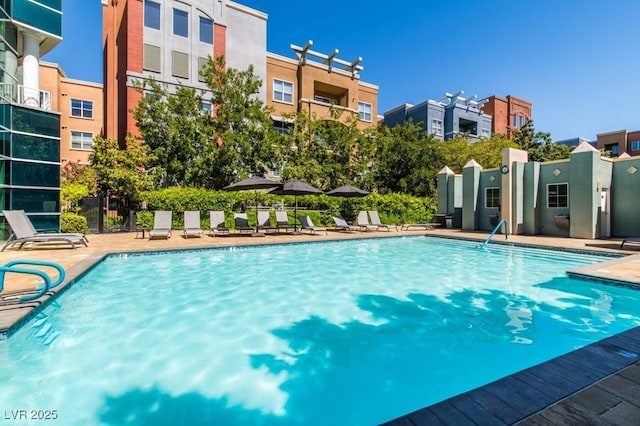 pool with a residential view, a patio, and fence