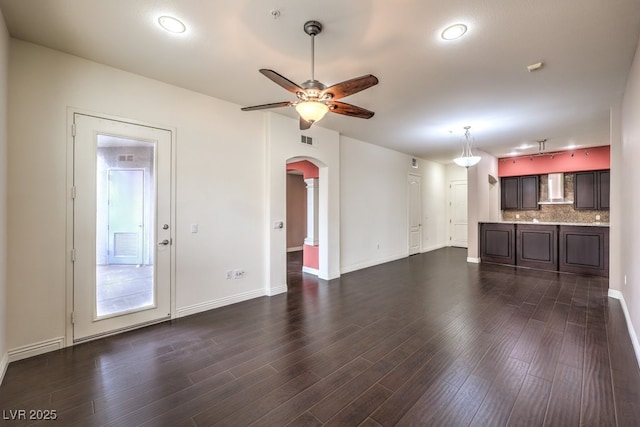 56 E Serene Ave Unit 306, Las Vegas, NV 89123 - unfurnished living room with a ceiling fan, arched walkways, dark wood-type flooring, and baseboards