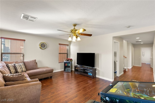 living area with baseboards, visible vents, wood-type flooring, and ceiling fan