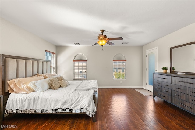 bedroom featuring visible vents, baseboards, hardwood / wood-style floors, and a ceiling fan