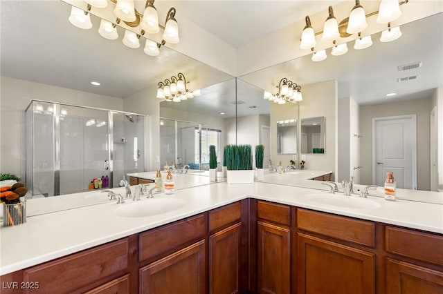 bathroom with double vanity, visible vents, a stall shower, and a sink