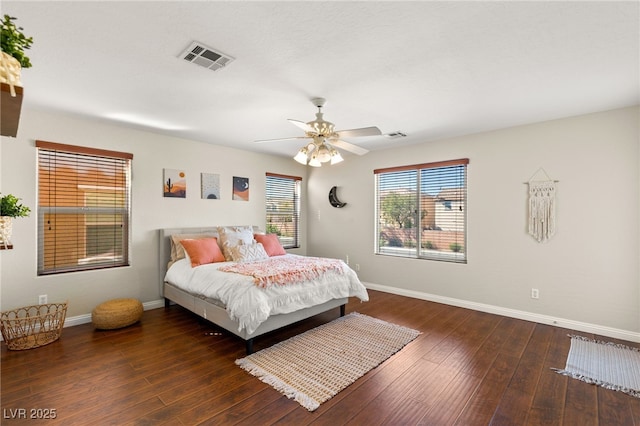 bedroom with visible vents, baseboards, ceiling fan, and hardwood / wood-style flooring