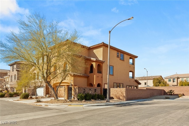 view of building exterior featuring a residential view and a fenced front yard