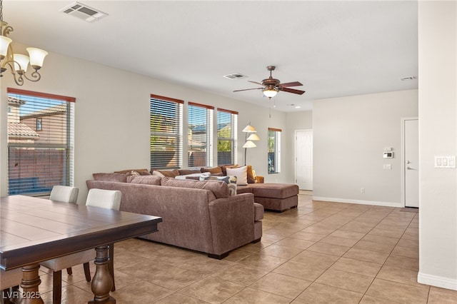 living room featuring light tile patterned floors, ceiling fan with notable chandelier, visible vents, and baseboards