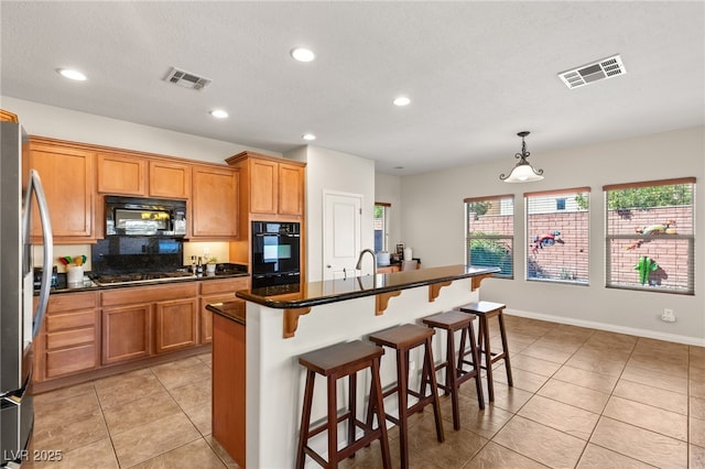 kitchen featuring visible vents, appliances with stainless steel finishes, and a breakfast bar area