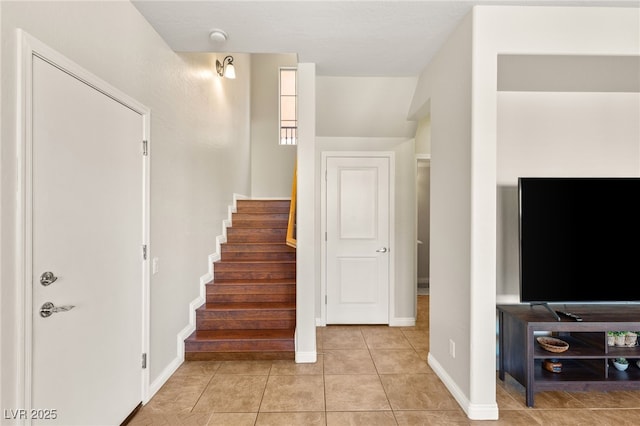 staircase with tile patterned floors and baseboards