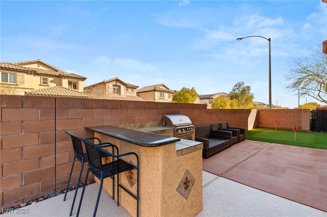 view of patio featuring grilling area, a fenced backyard, area for grilling, and outdoor dry bar