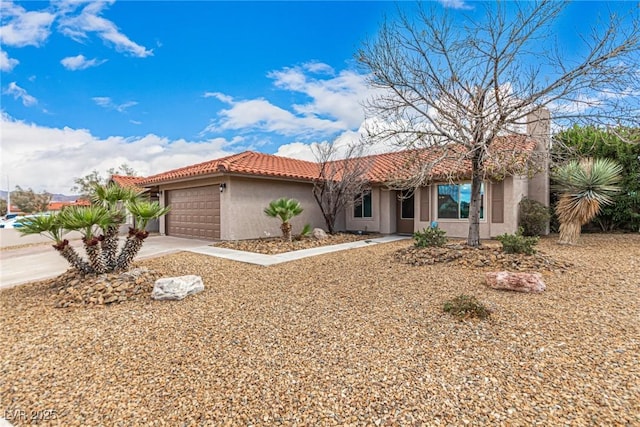 view of front of property with stucco siding, concrete driveway, a tile roof, and a garage