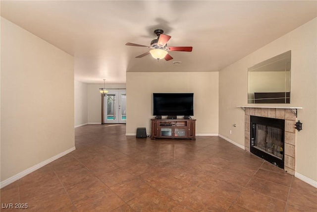 unfurnished living room featuring visible vents, a fireplace, baseboards, and ceiling fan