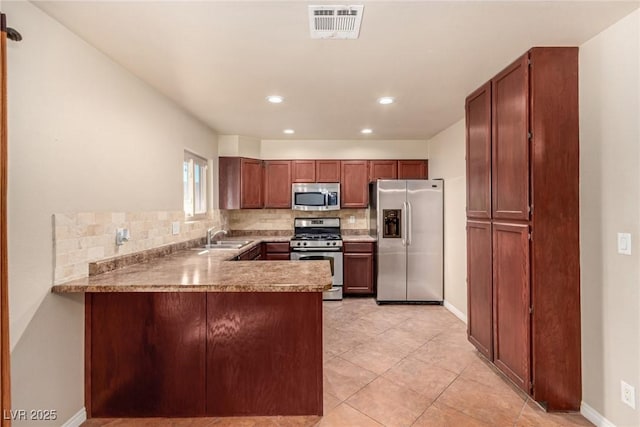 kitchen featuring tasteful backsplash, visible vents, a peninsula, and stainless steel appliances