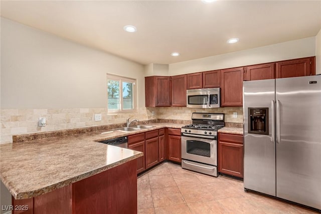 kitchen with a sink, appliances with stainless steel finishes, a peninsula, light tile patterned floors, and decorative backsplash