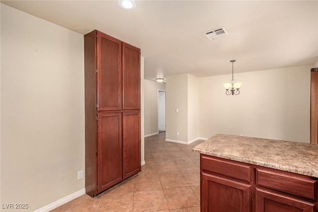 kitchen with decorative light fixtures, visible vents, baseboards, and light countertops