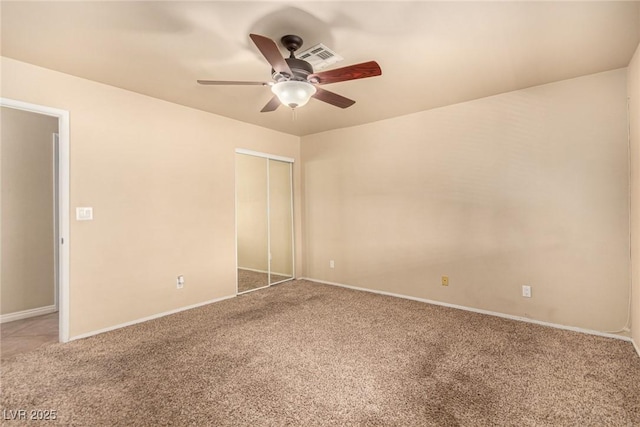 unfurnished bedroom featuring baseboards, a closet, carpet floors, and ceiling fan