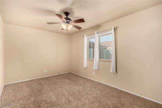 carpeted empty room with visible vents, baseboards, and a ceiling fan