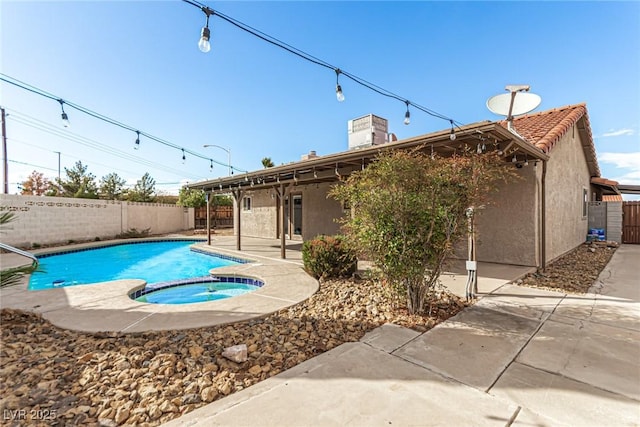 view of pool with a pool with connected hot tub, a fenced backyard, and a patio area