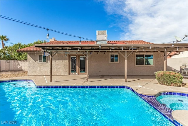 view of swimming pool with a patio area, fence, and a pool with connected hot tub