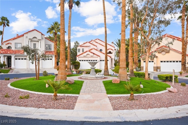 mediterranean / spanish house with stucco siding, an attached garage, a tile roof, and a front lawn